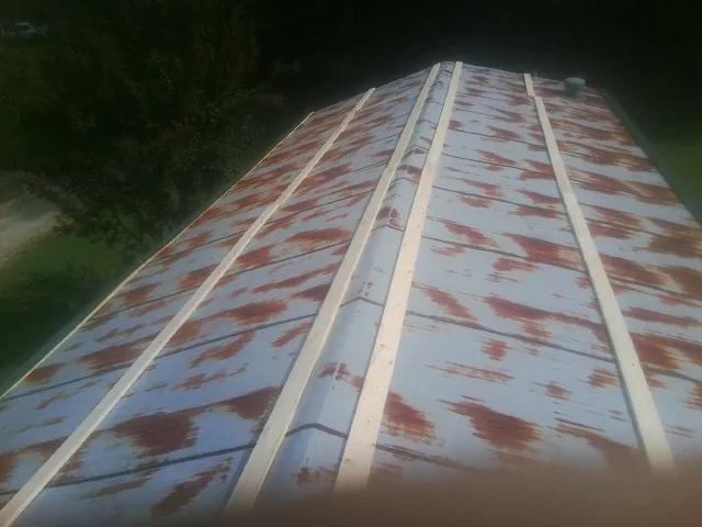 Rusted metal roof panels with new wood purlins before replacement — Storm Damage Roof Repair in Pebble Beach by Roofing Brothers